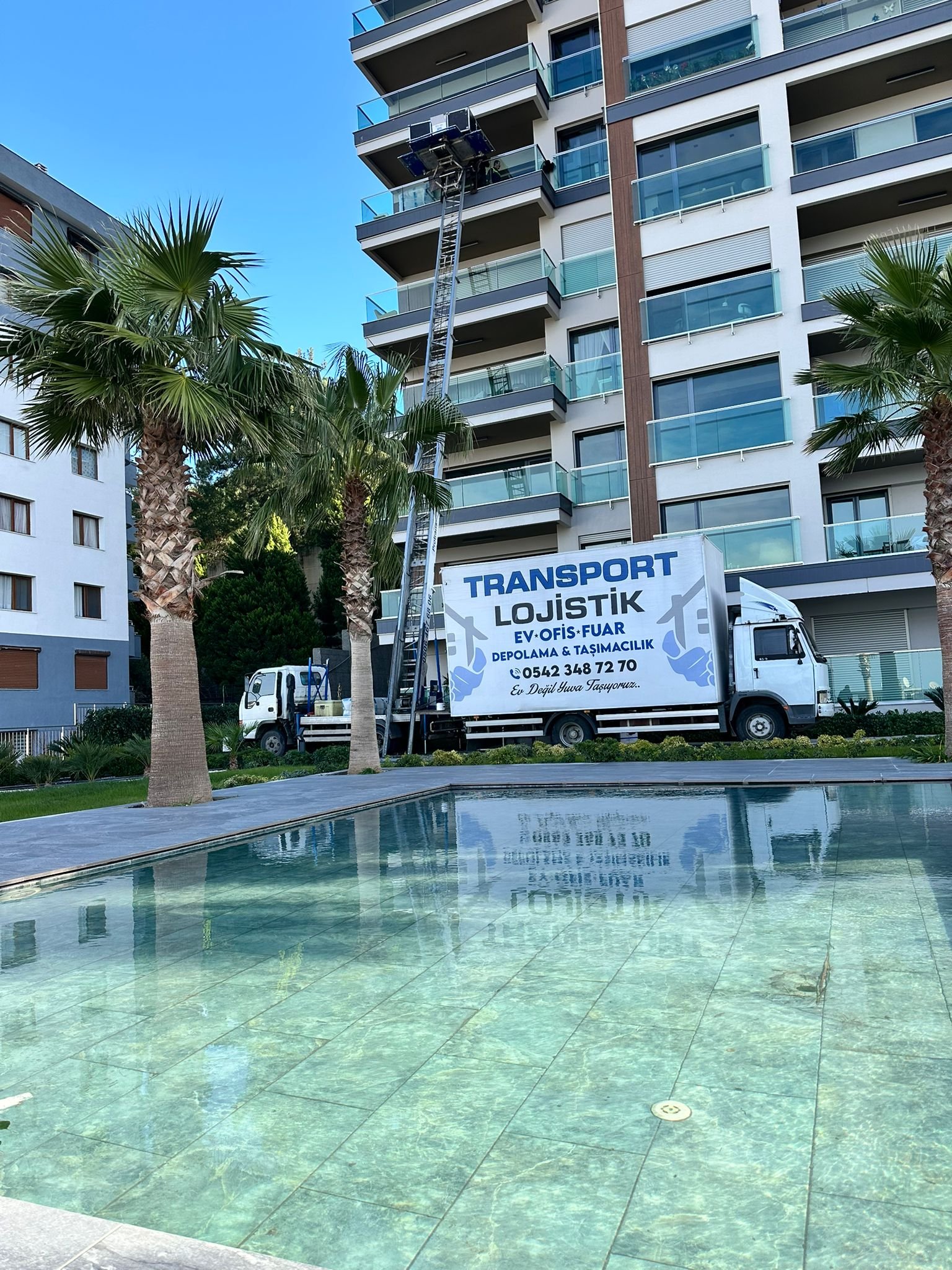 İzmir'de apartman önünde Transport Lojistik aracı ve dış cephe taşıma asansörü